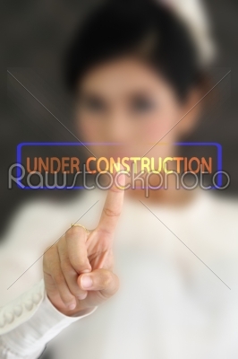 woman hand pressing under construction button on a touch screen 