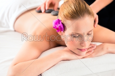 Woman having wellness spa hot stone massage
