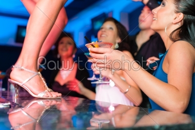 Woman in bar or club is dancing on the table