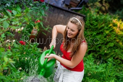 Woman in garden watering flowers