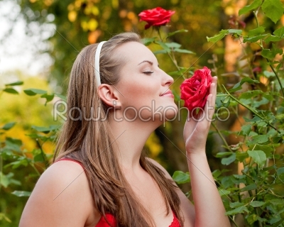 Woman in her garden sniffing at the roses