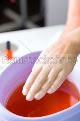 Woman in nail salon having paraffin bath