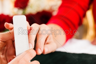 Woman in nail salon receiving manicure