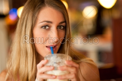 Woman in restaurant drinking milkshake