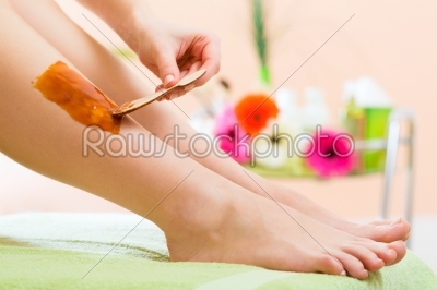Woman in Spa getting leg waxed for hair removal