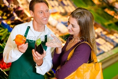 Woman in supermarket and shop assistant