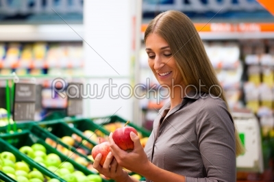 Woman in supermarket shopping groceries