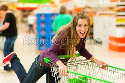 Woman in supermarket with shopping cart
