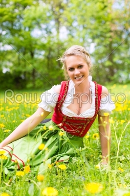 Woman in traditional Bavarian clothes or dirndl on a meadow