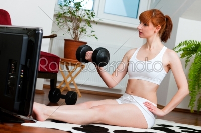 Woman is exercising with fitness video
