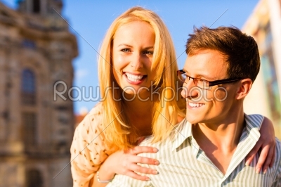 Woman jumping on the back of a man piggyback being happy