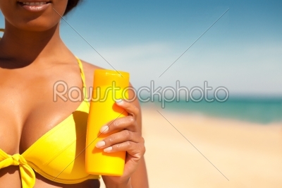 Woman offering suncream on beach