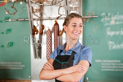 Woman or female butcher in butchers shop