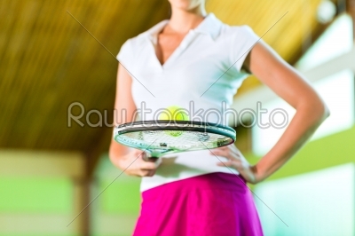 Woman playing tennis in fitness club