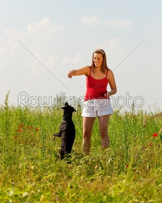 Woman playing with her dog in a meadow