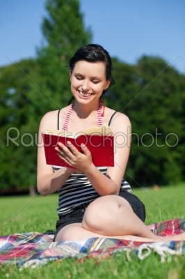 Woman reading book on meadow