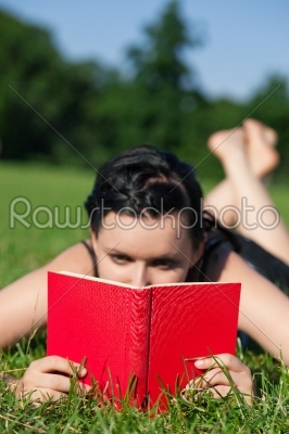 Woman reading book on meadow