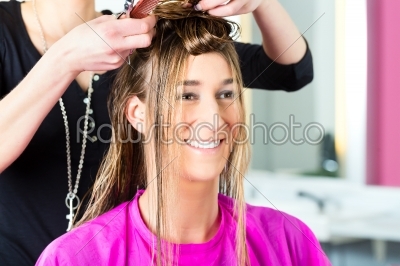 Woman receiving haircut from hair stylist or hairdresser