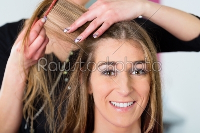 Woman receiving haircut in hairdressers shop