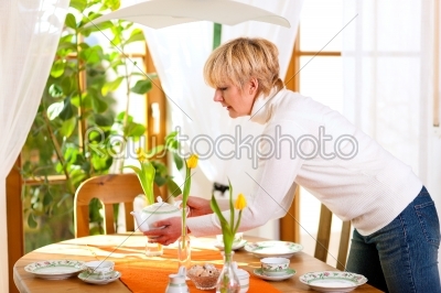 Woman setting the table for tea of coffee time