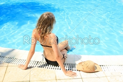 Woman sitting by the swimming pool