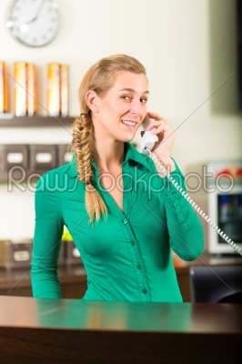 Woman taking a call at gym reception
