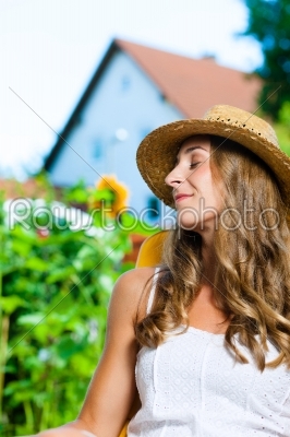 Woman tanning in her garden on lounge chair