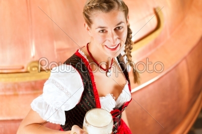 Woman with beer glass in brewery