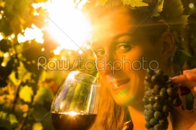 Woman with glass of wine in vineyard
