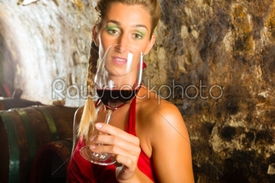Woman with glass of wine looking skeptically