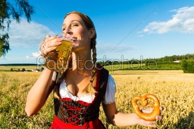 woman with tracht, beer and pretzel in Bavaria