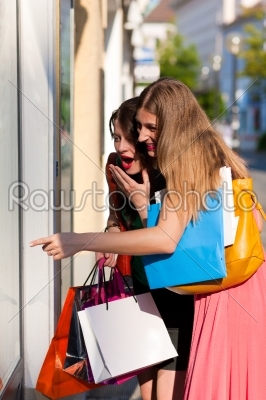 Women downtown shopping with bags