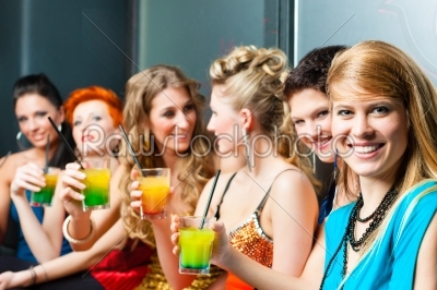 Women in club or disco drinking cocktails