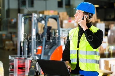 Worker with scanner and laptop at forwarding