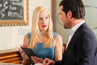 Working colleagues - a man and a woman - sitting in cafe