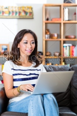 Young Asian woman at home on the sofa