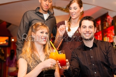 Young couple drinking cocktails in bar or restaurant