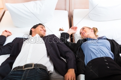 Young couple lying on bed in hotel room