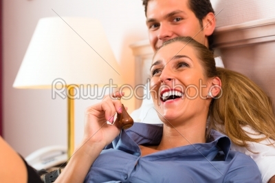 Young couple lying on bed in hotel room