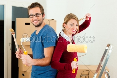 Young couple moving in a home or apartment, they are painting and doing renovation work 