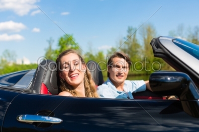 Young couple with cabriolet in summer on day trip