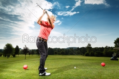 Young golf player on course doing golf swing