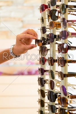 Young man at optician shopping sunglasses