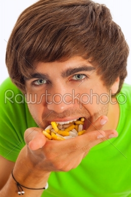 Young man feeding himself pills