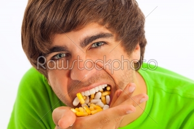 Young man feeding himself pills