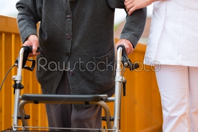 Young nurse and female senior with walking frame
