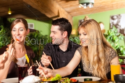 Young people eating in Thai restaurant