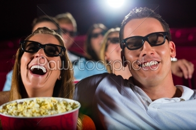 Young people watching 3d movie at movie theater