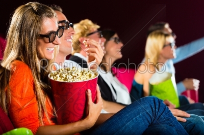Young people watching 3d movie at movie theater