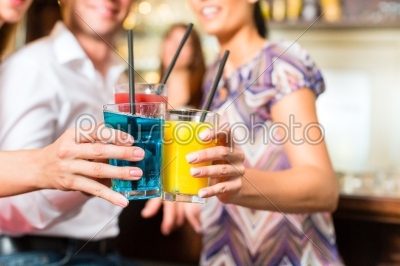 Young people with cocktails in bar
